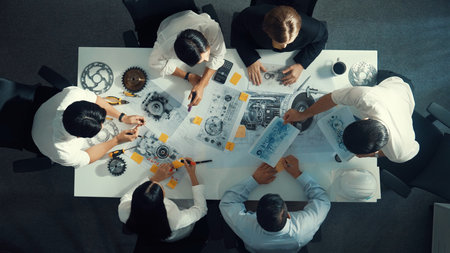Top view of engineer pointing at turbine engine at meeting table with equipment. Aerial view of professional project manager talking and discussing about electronic generator system.の写真素材