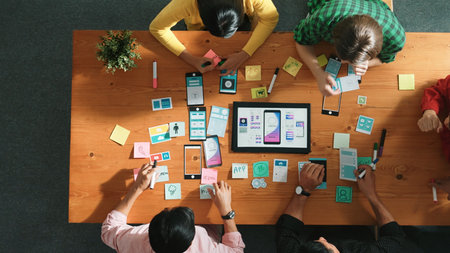 Top view of skilled software developer working together to develop Ux Ui design for mobile phone interface. Programmer sharing develop plan while looking at wireframe prototype icon. Convocation.の写真素材