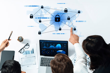 A business team works together to enhance data security measures with a focus on global connections, utilizing modern technology and data analysis in an office setting.の写真素材