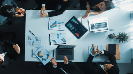 Top down aerial view of smart business team discuss about financial plan and finding solution. Group of diverse people working together and clapping hands to celebrate successful project. Directorate.の写真素材
