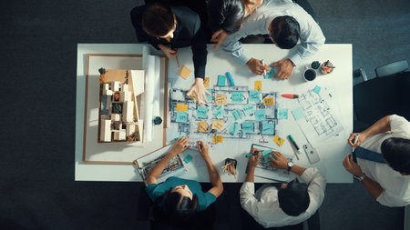 Time lapse of professional architect engineer team writing sticky notes and sticking note at house model while interior designer talking and discussing about building exterior designing.の写真素材