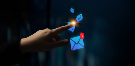 A hand interacts with glowing email icons while a notification symbol indicates new messages,...