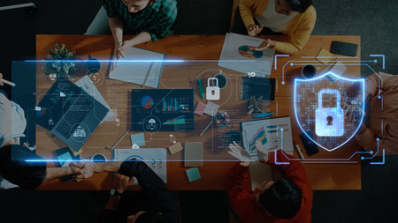 A top-down view of a team collaborating in a modern workspace, integrating technology and data security elements to enhance productivity and innovation. Rasterの写真素材