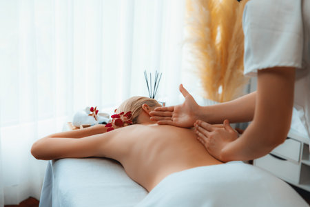 Caucasian woman customer enjoying relaxing anti-stress spa massage and pampering with beauty skin recreation leisure in day light ambient salon spa at luxury resort or hotel. Quiescentの写真素材