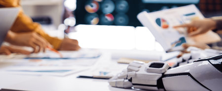 A dynamic business meeting with a diverse team analyzing various data and graphics. Advanced...