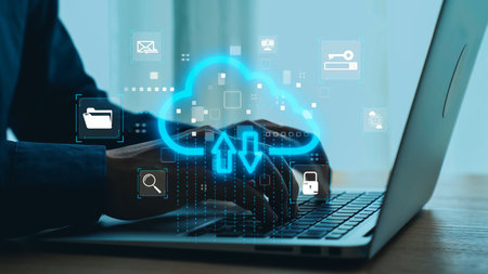 A close-up of hands typing on a laptop with a vibrant cloud storage concept displayed, showcasing...