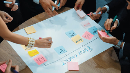 Close up of professional business team hands writing and putting sticky note on scrum task board. Top view of project manager write task and use kanban board to manage time and workflow. Directorate.の写真素材