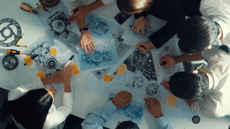 Top view of engineer pointing at turbine engine at meeting table with equipment. Aerial view of professional project manager talking and discussing about electronic generator system.の写真素材