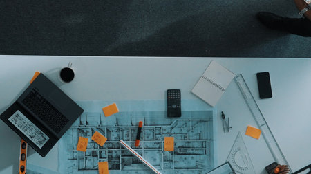 Top view of skilled architect engineer team looking at blueprint together. Aerial view of smart designer holding tablet while working together and brainstorming about building structure.の写真素材