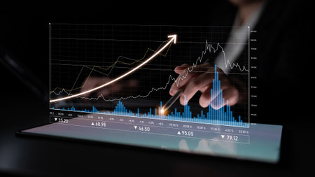 Business professional interacting with digital financial charts on a tablet screen, highlighting...