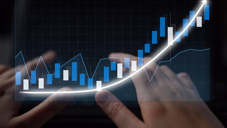 A close-up view of hands engaging with a digital financial graph, showcasing a strong growth trend....