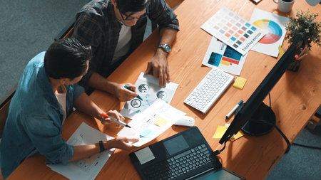 Top view of manager writing idea while team standing and giving comment. Professional designer design logo while looking at color palette and writing idea down in paper with color marker. Symposium.の写真素材