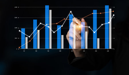 A hand with a glowing orb engages with various graphs and charts on a dark background, symbolizing financial analysis and business growth strategies.の写真素材