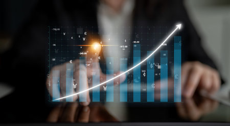 A business professional engages with a digital financial graph highlighting an upward trend,...
