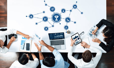 A modern office scene showcasing a collaborative business meeting focused on strategy and data analysis, featuring charts, visuals, and a trophy symbolizing success.の写真素材