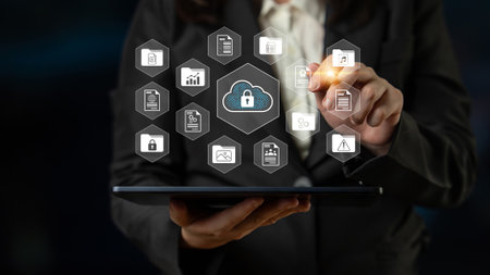 A business professional interacts with a digital cloud security interface on a tablet device, showcasing modern technology and data protection in a professional workspace.の写真素材