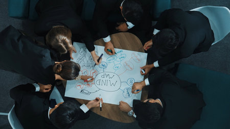 Top down aerial view of group of smart diverse business people brainstorm marketing idea while writing mind map. Creative team working together to share strategy while using mind mapping. Directorate.の写真素材