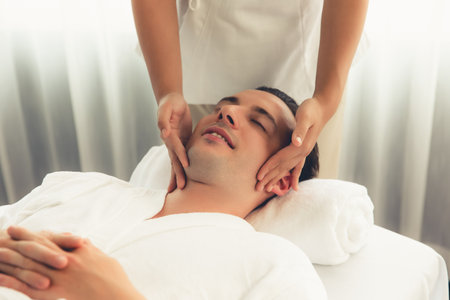 Caucasian man enjoying relaxing anti-stress head massage and pampering facial beauty skin recreation leisure in dayspa modern light ambient at luxury resort or hotel spa salon. Quiescentの写真素材