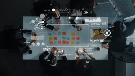 Diverse professionals engage in a collaborative meeting around a table filled with sticky notes,...