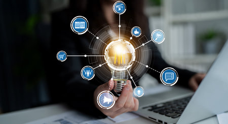 A business professional demonstrates innovative thinking by holding a light bulb while surrounded by...