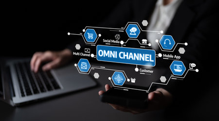 A modern workspace showcasing a professional using a smartphone and laptop to explore omni-channel marketing. The image highlights technology and customer engagement strategies. Tesselの写真素材