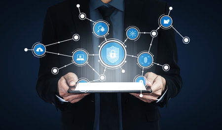 A businessman holds a tablet displaying digital icons connected by lines, symbolizing innovation,...