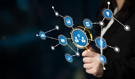 A business professional examines digital icons with a magnifying glass, representing data analysis...