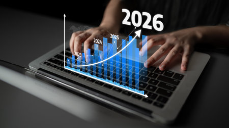 Close-up of hands typing on a laptop keyboard with an overlaid graphical chart showing growth trends...
