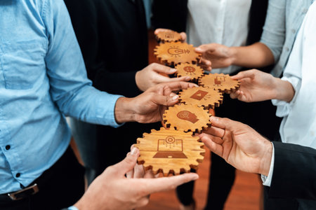 A captivating image showcasing hands exchanging wooden gears adorned with icons, symbolizing collaboration and innovation in the business landscape and teamwork dynamics.の写真素材