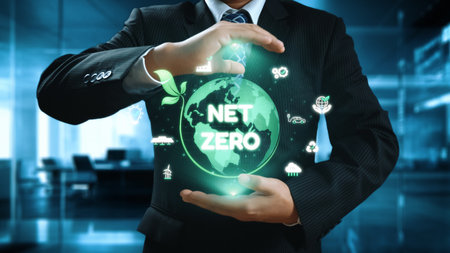 A businessman in a suit holds a glowing digital globe symbolizing net zero emissions and the importance of sustainability. The image represents eco-friendly business practices.の写真素材
