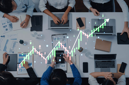 A collaborative business meeting where professionals analyze data and growth charts on laptops,...