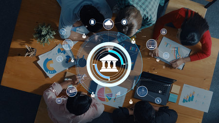 A business team collaborates in a modern office, analyzing financial charts while utilizing digital...