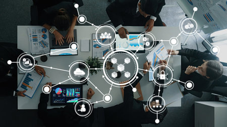 A top-down view of a business meeting showcasing professionals discussing strategies with digital...