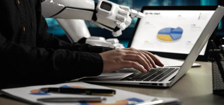 A modern workspace showcasing a human interacting with a laptop while a robot assistant displays...