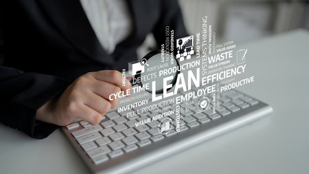 Close-up view of a hand working on a keyboard in an office environment, illustrating key lean...