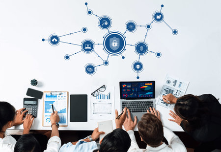 A team gathers around a table, collaborating on cybersecurity strategies and data analysis. They...