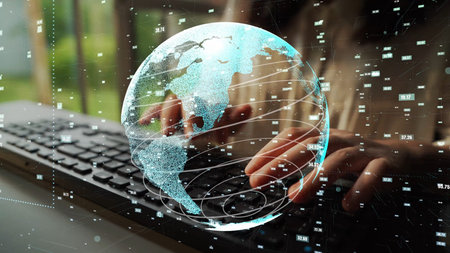 A conceptual image showing a person typing on a keyboard with a transparent digital globe overlay,...