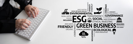 A business professional types on a keyboard while engaging with themes of ESG and green business....