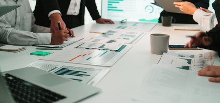 A diverse business team collaborates in a modern office environment. They analyze financial reports...