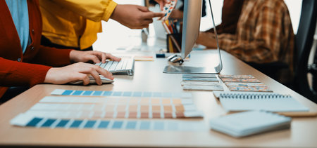 A vibrant workspace shows creative professionals actively collaborating, sharing color samples, and...