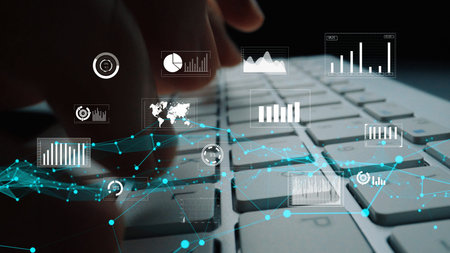 A close-up image featuring hands typing on a laptop keyboard with floating digital graphs and data...
