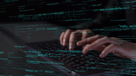 A dramatic close-up of hands typing on a laptop keyboard, while streams of programming code...