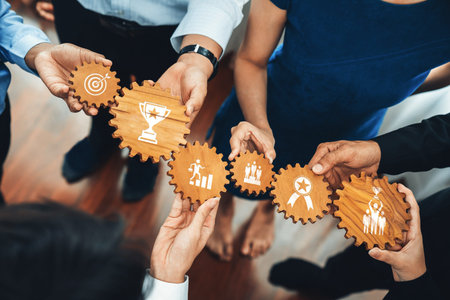 A diverse group of professionals collaborates by holding interconnected gears, each symbolizing key...