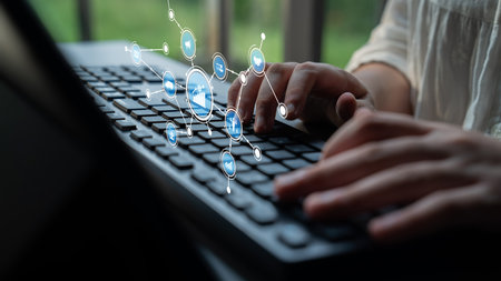 A close-up view of a person typing on a keyboard, surrounded by digital icons symbolizing...