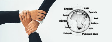 Close-up of diverse hands interlocking over a globe marked with various language labels, representing global collaboration and unity among cultures and communities.の写真素材