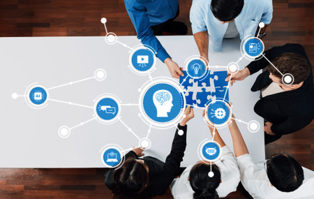 A diverse team engages in collaborative problem-solving around a table, connecting puzzle pieces with digital icons representing technology and innovation in business.の写真素材