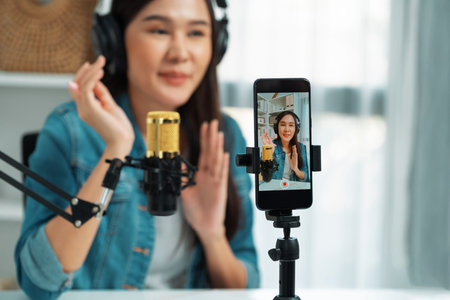 Host channel influencer talking in broadcast wearing headsets on social media live on smartphone...