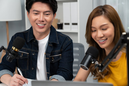 Smiling radio influencer hosts with channel social media online live streaming with talking topic...