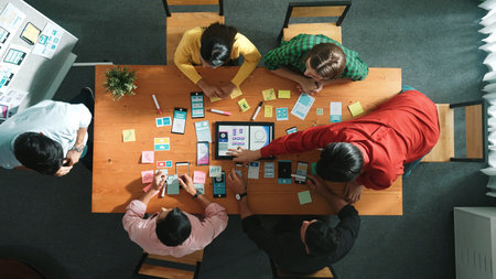 Top view of software developer writing idea about Ux ui design for mobile phone interface. Programmer brainstorm and planning wireframe prototype by looking tablet display.の写真素材