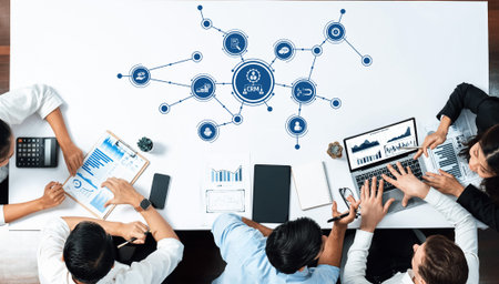 A group of business professionals collaborates on a CRM strategy, utilizing various technology...